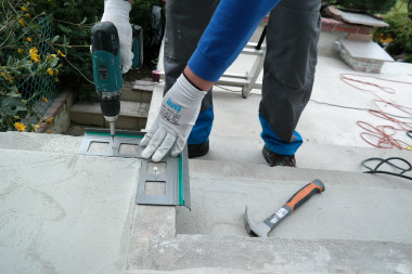 Hydroizolacja tarasu nad pomieszczeniem - przykładamy narożnik w miejsce jego montażu, wywiercamy otwory, osadzamy kołki rozporowe