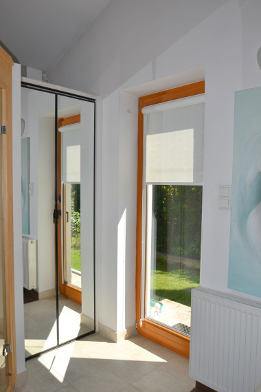 Drzwi narożnej sauny ulokowane w pobliżu okna tarasowego