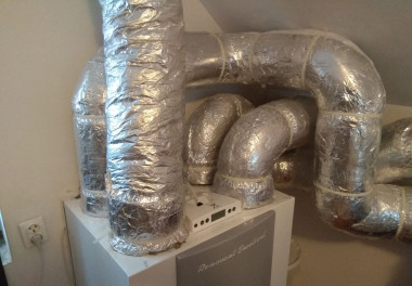 Zaizolowane przewody wentylacyjne i regulator na obudowie centrali