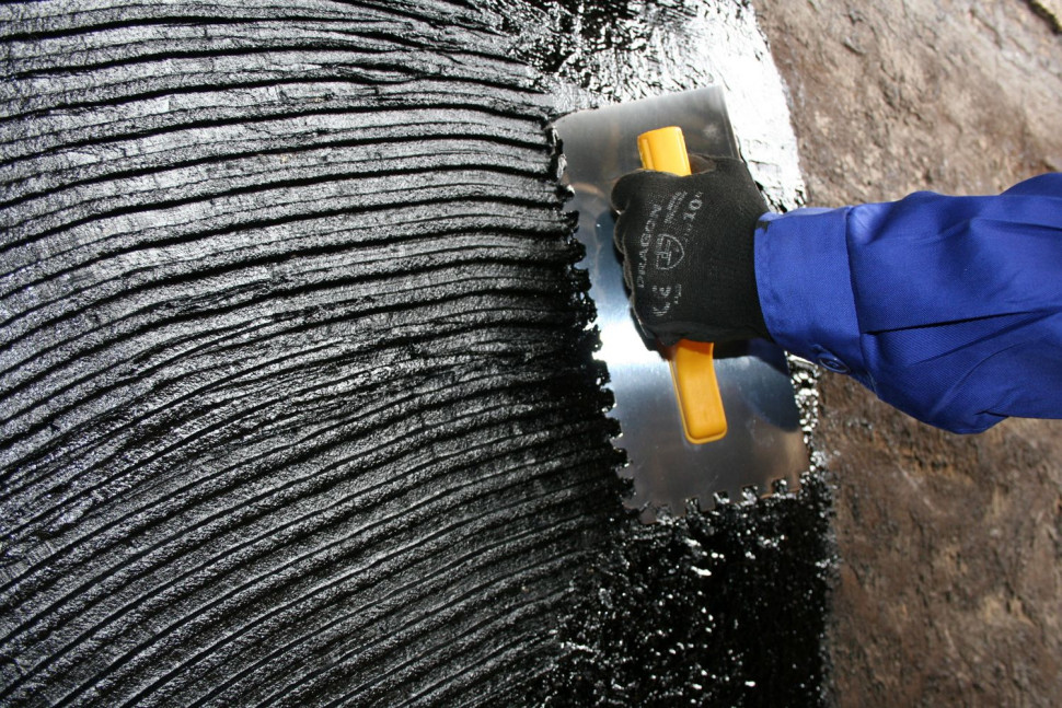 Nakładanie masy szpachlowej FUNDABIT na dużą powierzchnię pionową za pomocą szpachli ząbkowanej. Fot. IZOLACJA – JAROCIN S.A. 