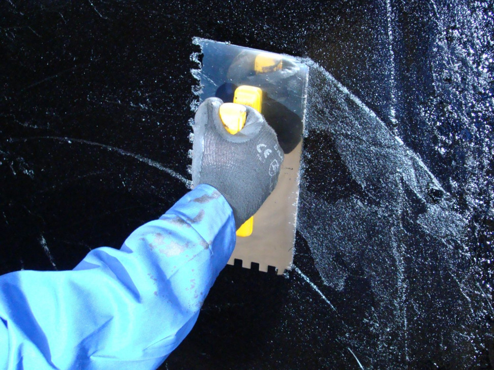 Nakładanie masy szpachlowej FUNDABIT na pionową powierzchnię fundamentu zagruntowaną roztworem asfaltowym JARLEP G. Fot. IZOLACJA – JAROCIN S.A.