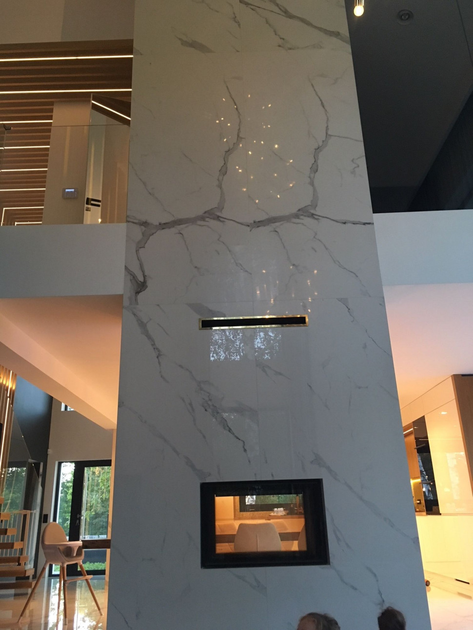 Ściana z kominkiem wykończona płytami gresu 120 × 240 cm