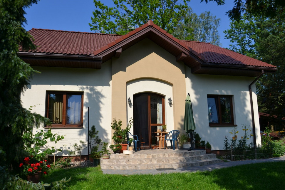 Łuki nad drzwiami na frontowej i ogrodowej elewacji dekorują prostą bryłę budynku