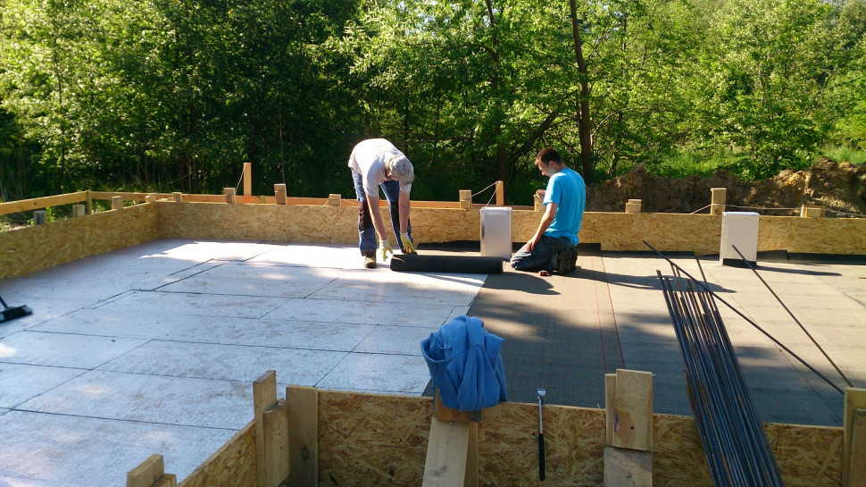 Wykonywanie fundamentów. Układanie hydroizolacji na ociepleniu płyty fundamentowej