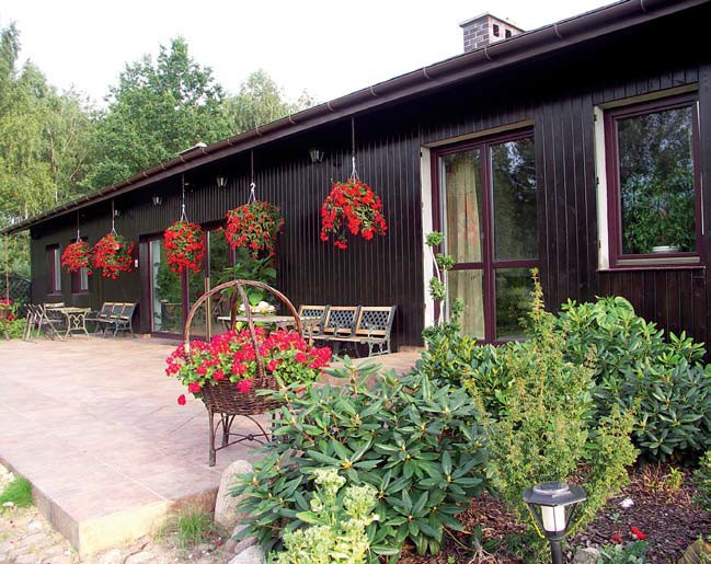 Właściciel chciał mieć taras od północy, aby domownicy nie cierpieli od nadmiaru słońca. Obserwatorzy, siedzący na tak usytuowanym tarasie, nie patrzą pod słońce. Po tej stronie domu drewniana elewacja, mimo pomalowania na ciemnobrązowy kolor, nie nagrzewa się