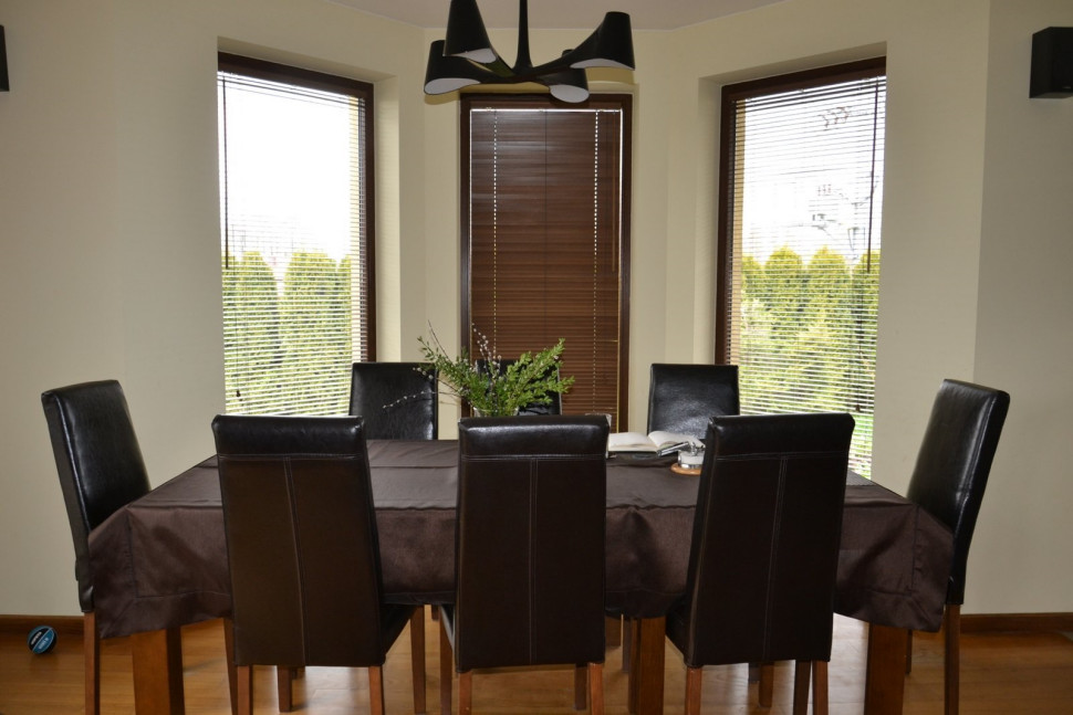 Wewnętrzne żaluzje z drewna na oknach w salonie