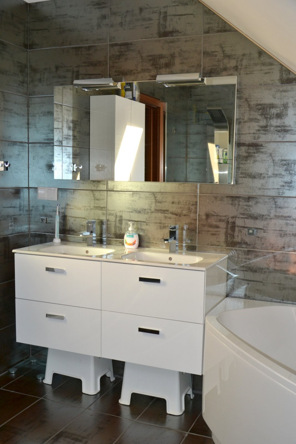 Dwie umywalki i zabudowa z poręcznymi szufladami w łazience na poddaszu