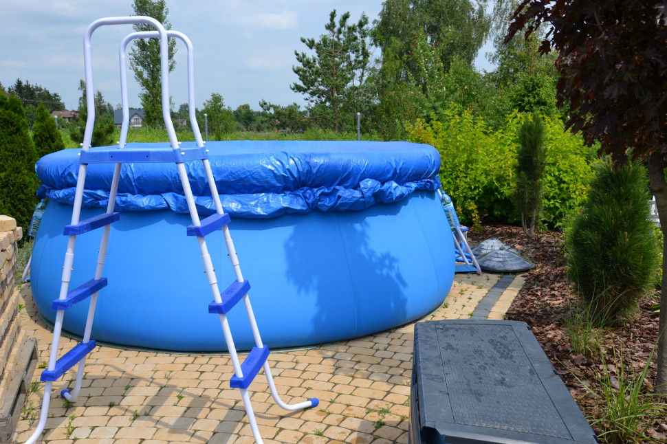 Rozkładany basen ogrodowy, pod nim nawierzchnia z kostki brukowej