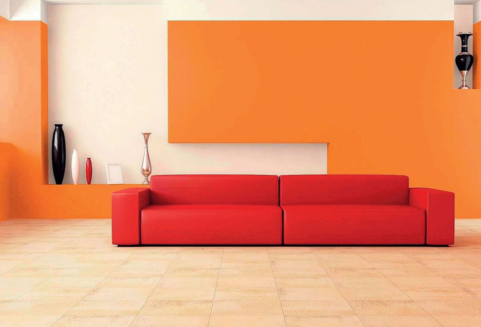 Wnętrze pomalowane na pomarańczowo z czerwoną sofą