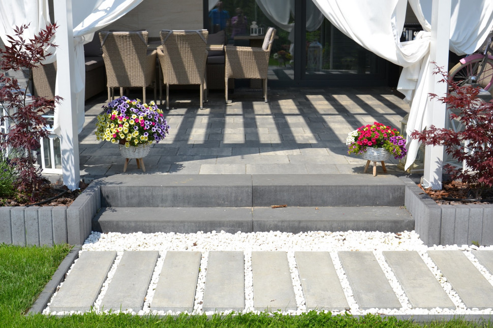 Przy tarasie i ganku z kostką betonową zastosowano palisadę z betonu