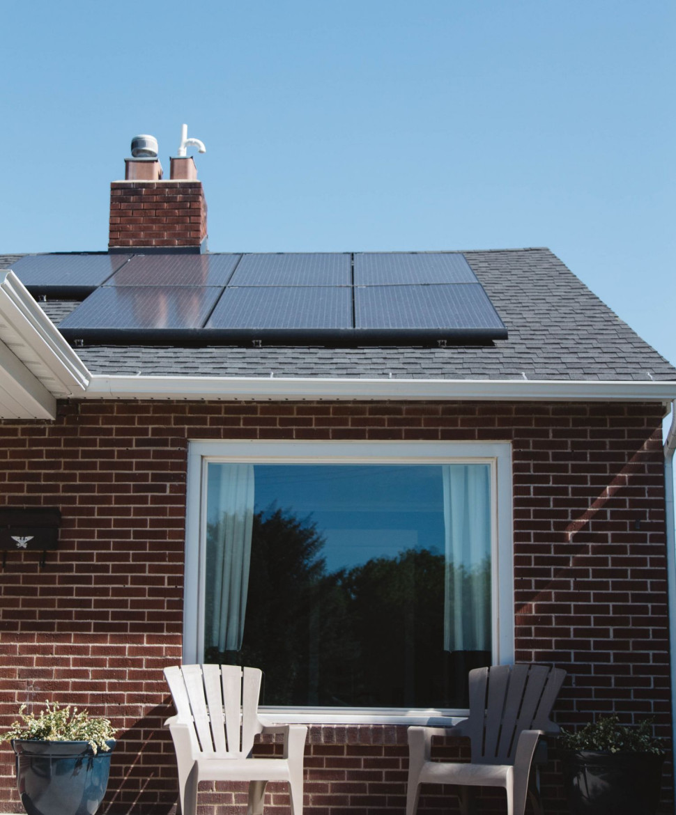 Panele fotowoltaiczne zamontowane na dachu krytym gontem bitumicznym. Widoczny cień od komina.