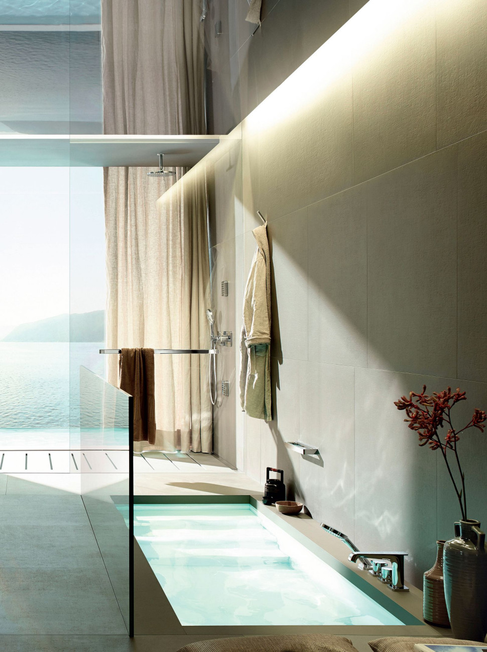 Zanurzona w posadzce wanna i otwarty natrysk tworzą atmosferę tropikalnych wakacji. Komponenty kolekcji Axor Citterio E, zaprojektowanej przez Antonio Citterio.