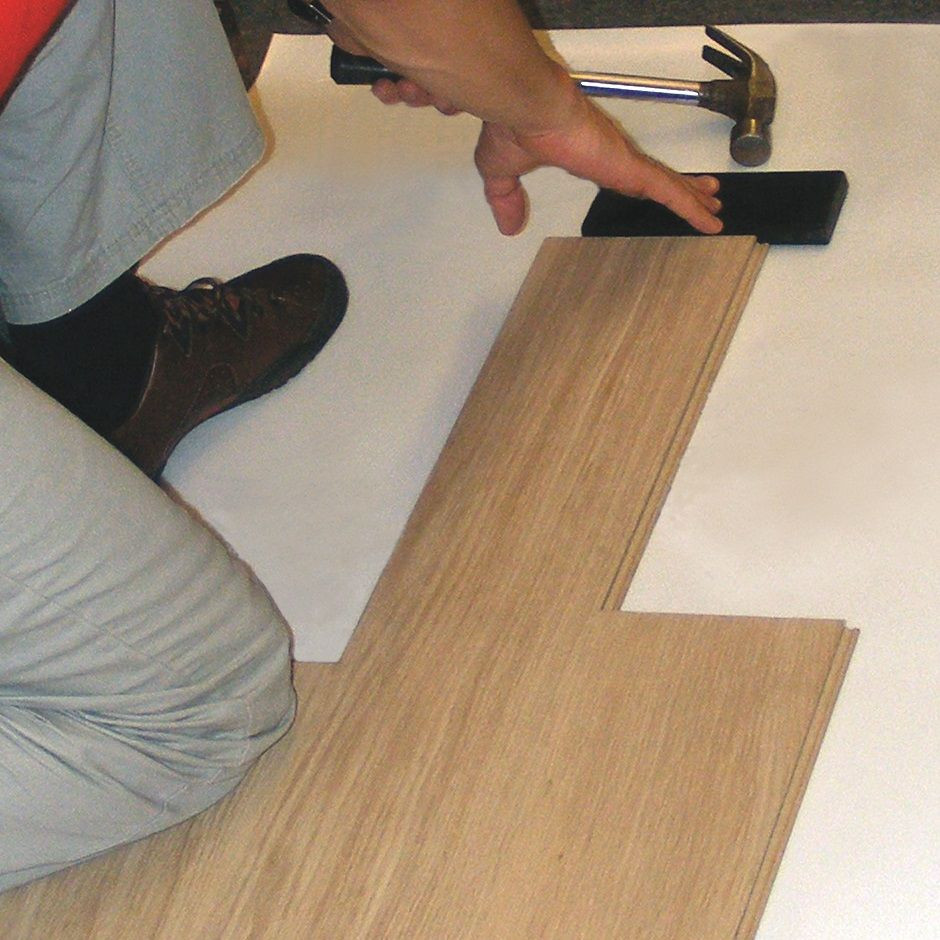 Montaż paneli podłogowych: poszczególne panele dobijane młotkiem i dobijakiem