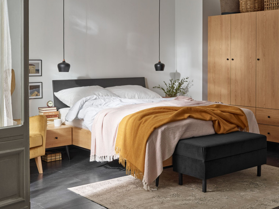 Musztardowy koc na łóżku w sypialni