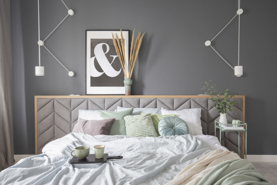 Łóżko z szerokim zagłówkiem w sypialni