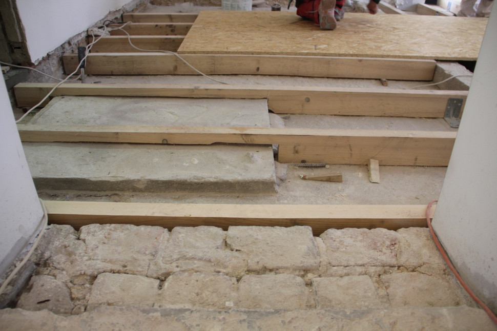 Przejście z korytarza do pokoju po rozpoczęciu odbudowy konstrukcji podłogi