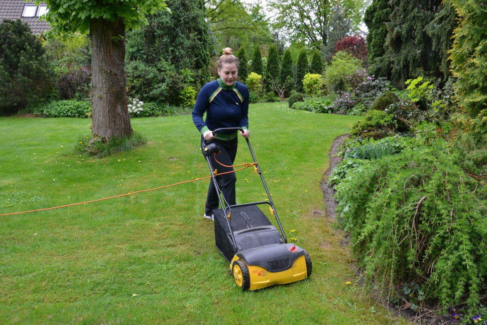 Ola używa elektrycznego wertykulatora do trawnika