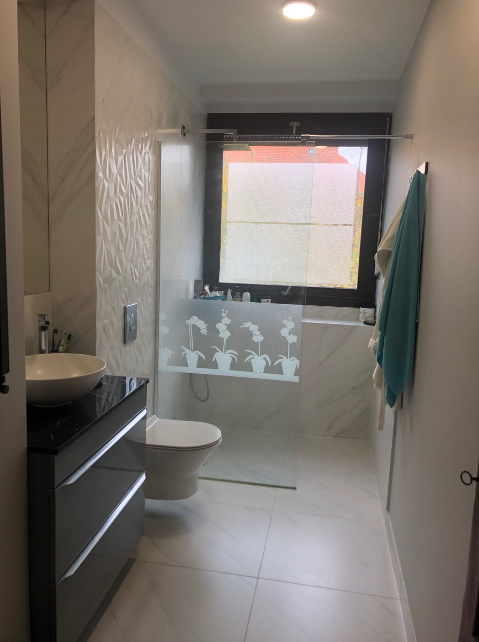 Wannę zastąpiono obszerną kabiną prysznicową typu walk-in, założono wodną podłogówkę