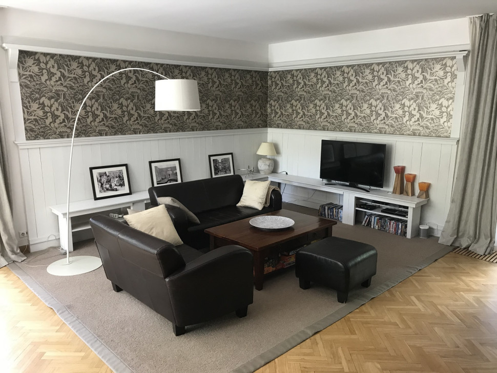 Nowy wystrój salonu nabrał elegancji po rozłożeniu wielkiego dywanu oraz wykończeniu ścian białą boazerią i wklejeniu w nią włoskiej tapety