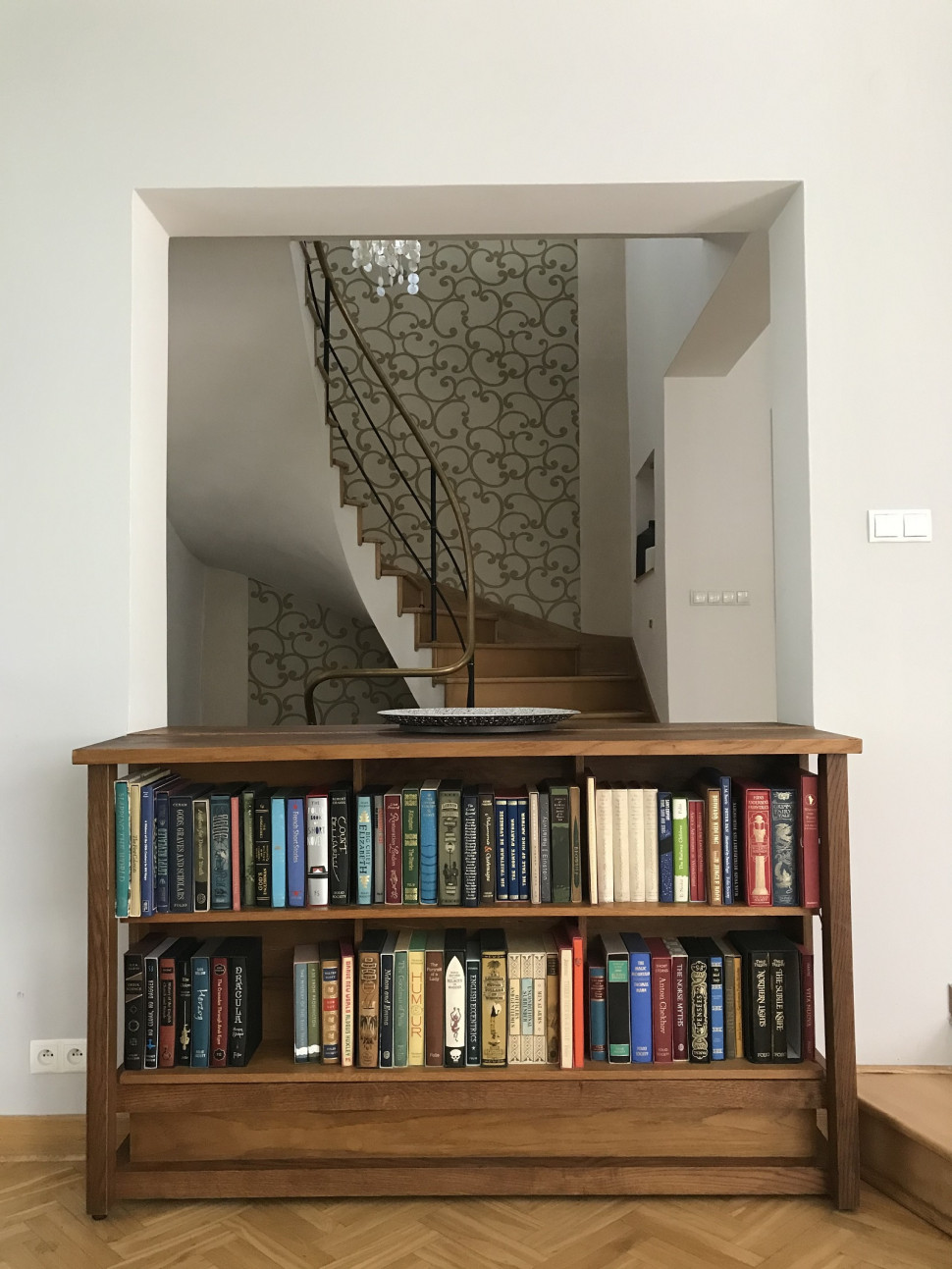 Domowa biblioteka ustawiona na granicy strefy dziennej i klatki schodowej