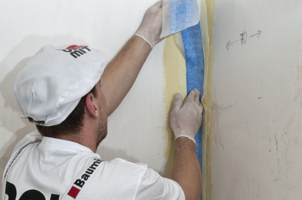 Wklejanie taśmy uszczelniającej w narożu ścian, w miejscu gdzie będzie kabina prysznicowa