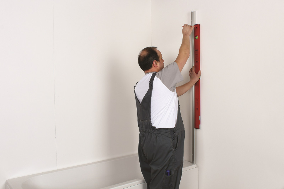 Za pomocą poziomnicy zaznaczamy miejsca mocowania listew do ściany i wiercimy otwory pod kołki rozporowe