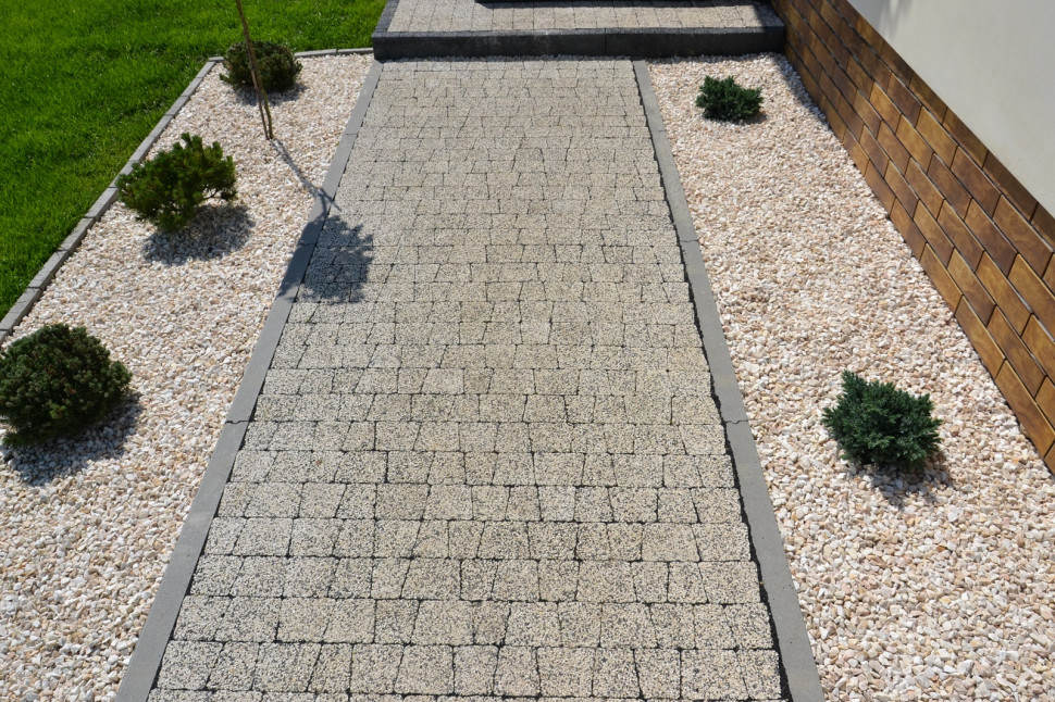 Właściciele objęli krawężnikami z betonu ścieżkę z dwuwarstwowej kostki betonowej (imituje granit)