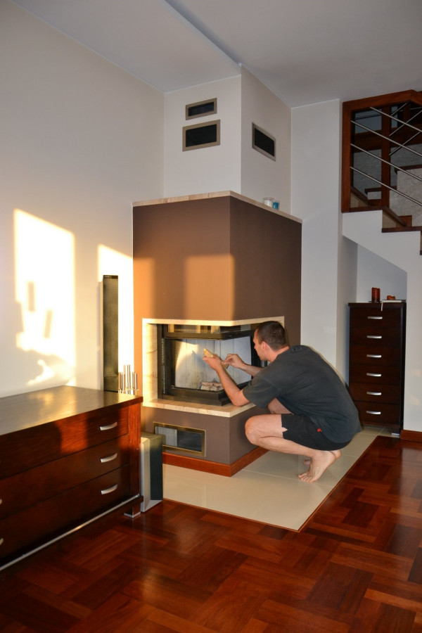 Narożna szyba podnosi się, co ułatwia dostęp do paleniska