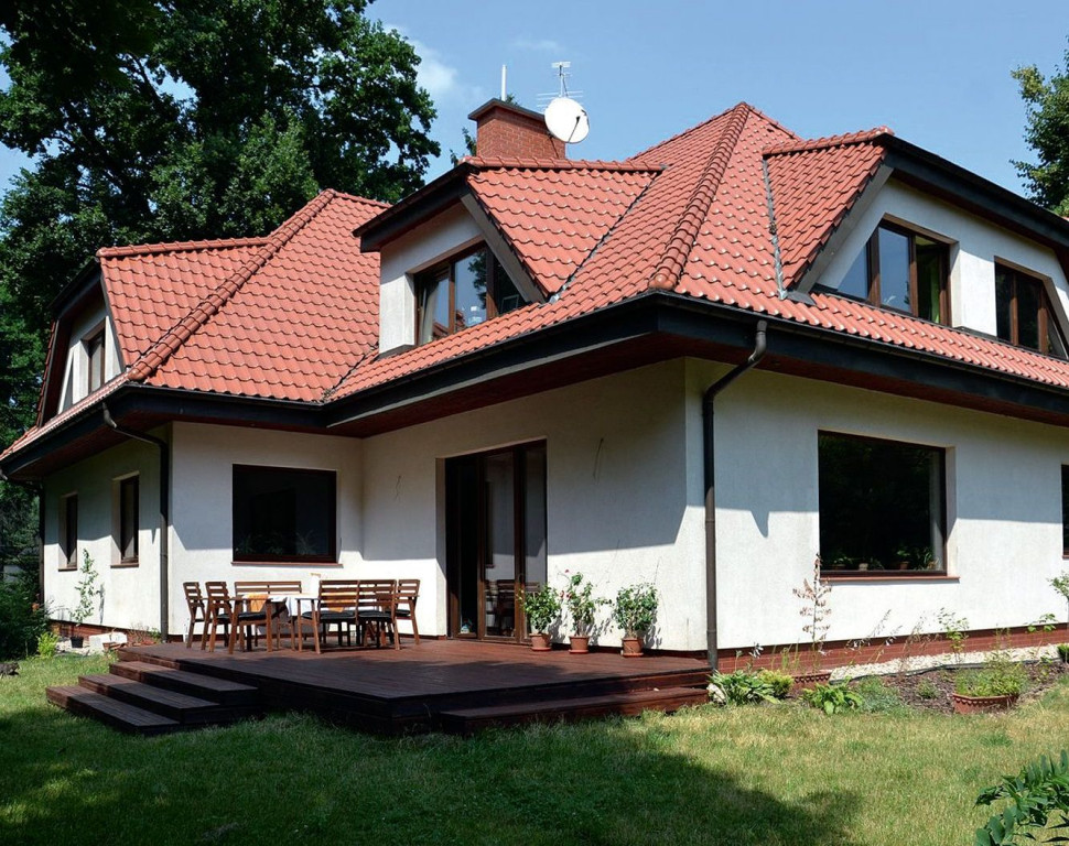 Przytulając dom do północnego boku działki, właściciele znacznie powiększyli strefę wypoczynkową od strony południa i zachodu