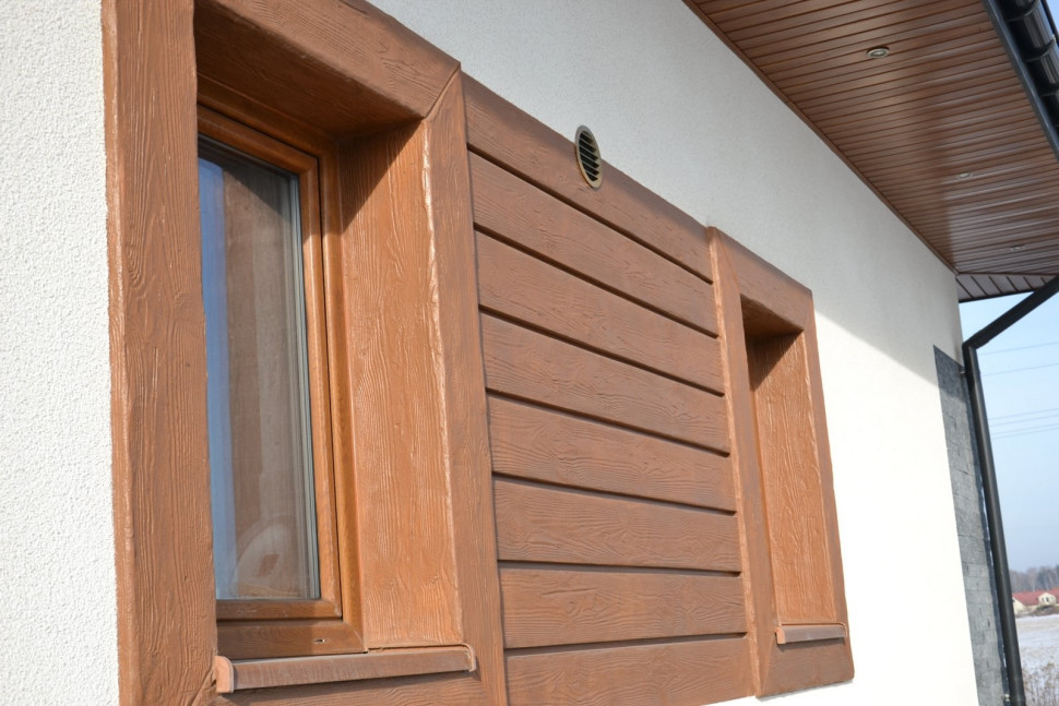 Elementy imitujące bale wykonano ze specjalnej zaprawy tynkarskiej, szablonu i bejcy (jej barwę dobrano do ram okien)