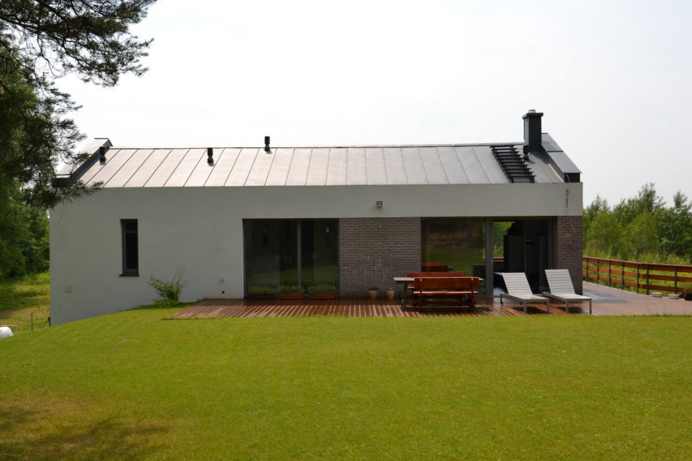 Widok od strony lasu. Budynek stoi równolegle do skarpy, ciągnącej się wzdłuż północnej części posesji