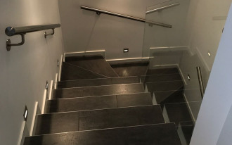 Schody zabiegowe obłożone gresem w czterokondygnacyjnym domu