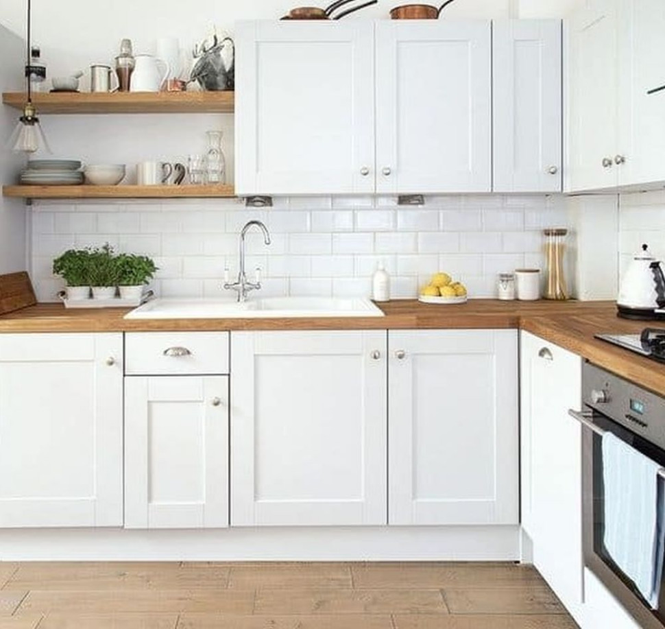 Połączenie drewnianego blatu z białymi szafkami kuchennymi