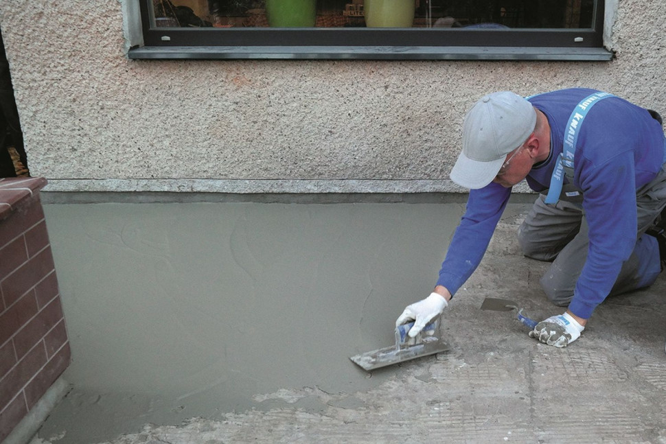 Hydroizolacja tarasu nad pomieszczeniem - po wtopieniu taśmy uszczelniającej nakładamy pierwszą warstwę hydroizolacji