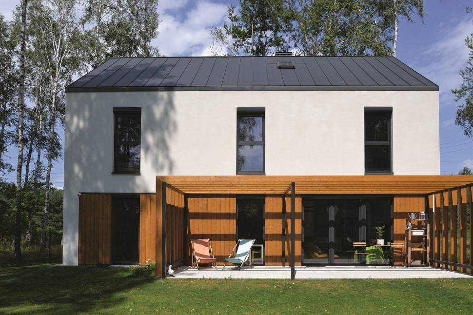 Przy tylnej południowej elewacji domu znajduje się taras, lekko zacieniony pergolą z drewna świerkowego