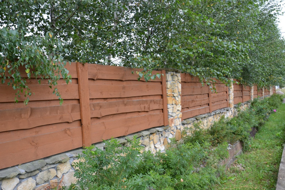 Dokupiona działka ma ogrodzenie z piaskowca i drewna. Deski sosnowe ułożono w poziomie