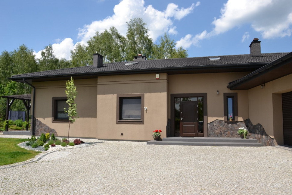 Elewacje pokryto tynkiem mineralnym i pomalowano farbą fasadową w kolorze kawa z mlekiem