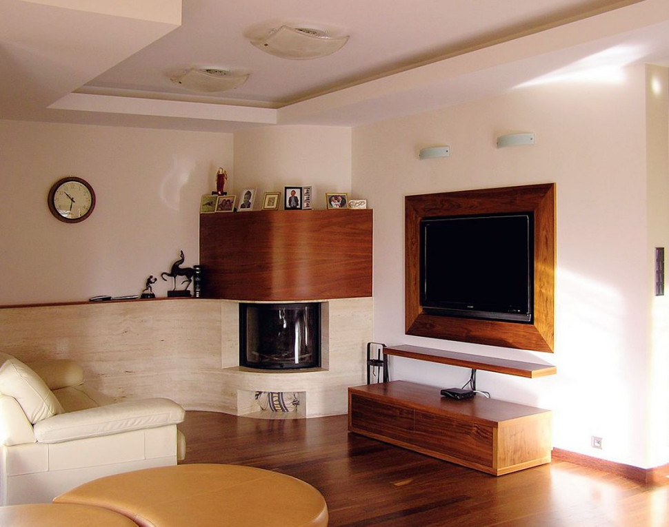 W salonie zamontowano kominek z płaszczem wodnym, który wykończono trawertynem i egzotycznym drewnem