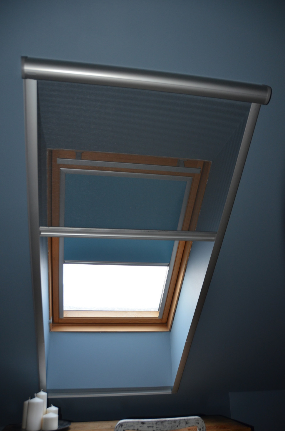 Uchylne okno w sypialni małżeńskiej ma roletę wewnętrzną oraz moskitierę