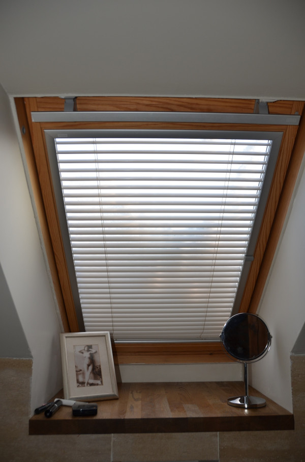 W oknie dachowym w łazience zamontowano wewnętrzną żaluzję