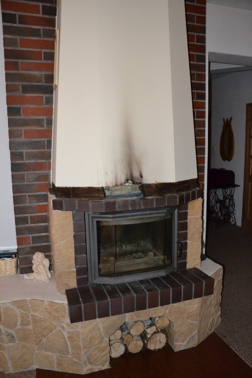 Obudowa nad żeliwnym wkładem kominkowym rozszczelniła się. Drewniana belka pod czopuchem zaczęła się tlić