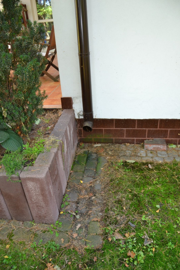 Deszczówkę odprowadza się po opasce wokół budynku (z kostki betonowej) i po powierzchni piaszczystego gruntu