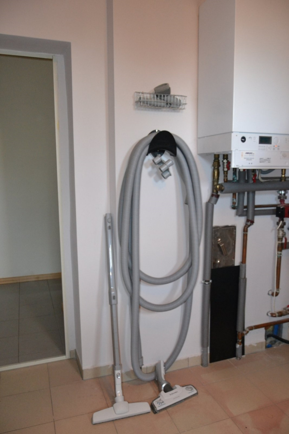 Wąż (9 m) z akcesoriami przechowuje się na wieszakach i w koszyczkach, w kotłowni