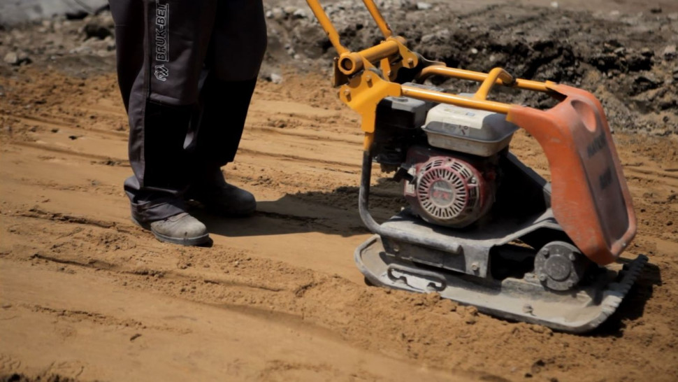 Warstwy podbudowy (nośną z grubszego kruszywa oraz podkładową z piasku) ubija się za pomocą zagęszczarki mechanicznej