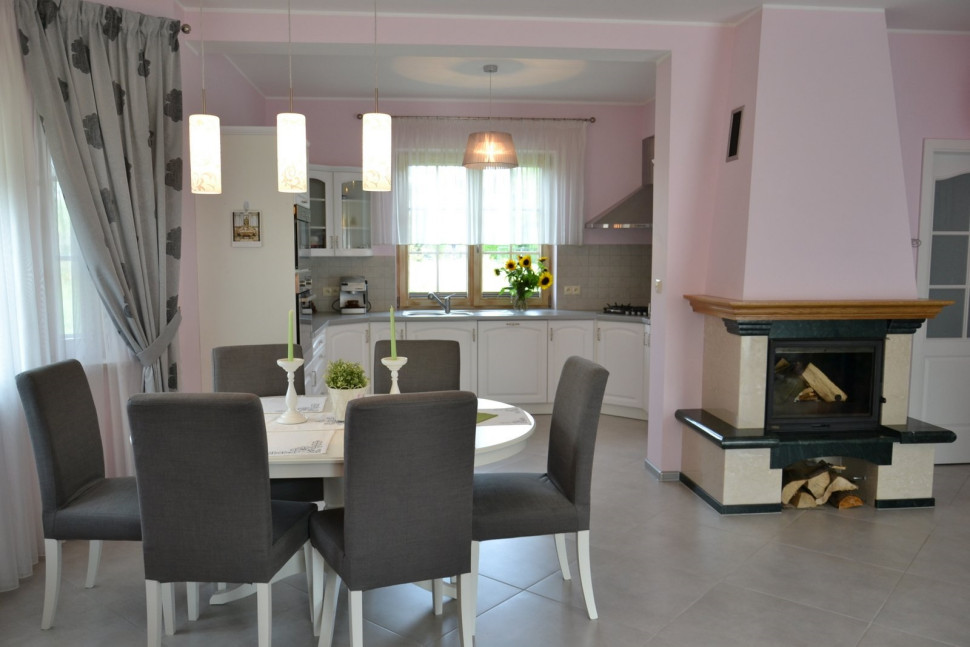 Meble jadalniane ustawiono w zgrabnej wnęce, w bezpiecznej odległości od kominka