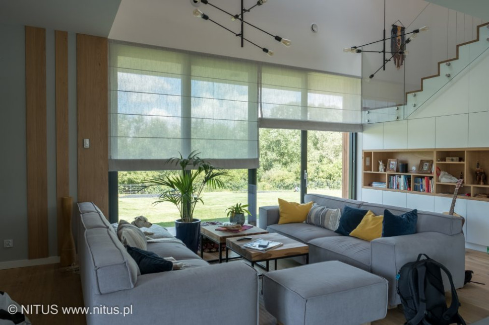 Pomieszczenie z dużymi oknami i żaluzjami