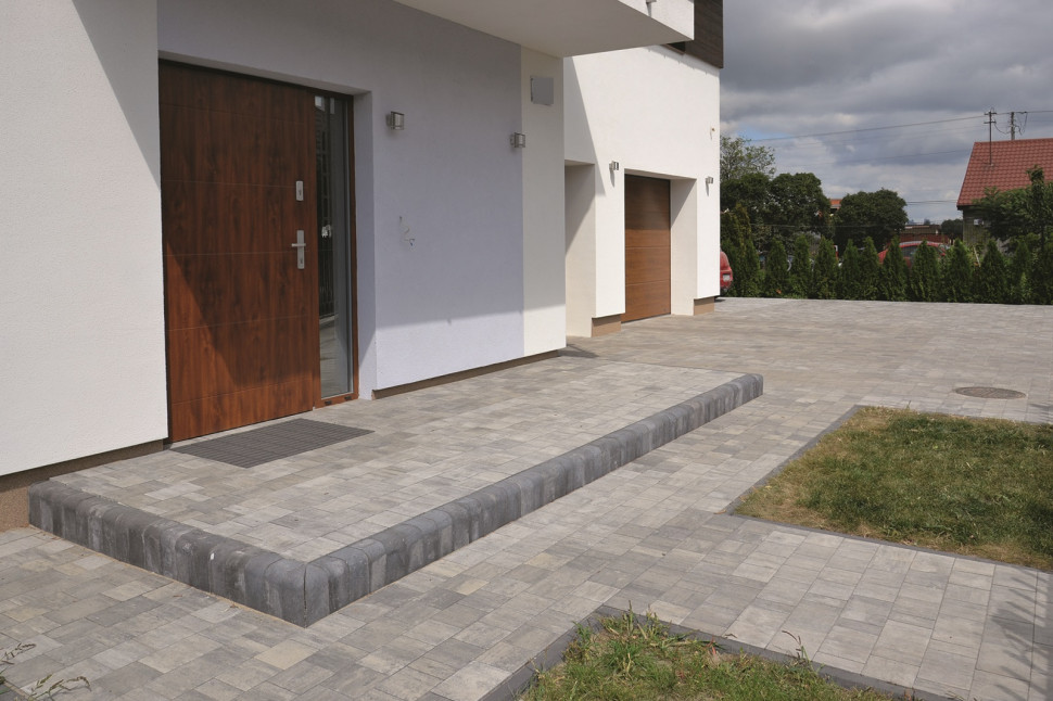 Ganek, podjazd i trakty komunikacyjne (120 m2) utwardzone szarą kostką z betonu