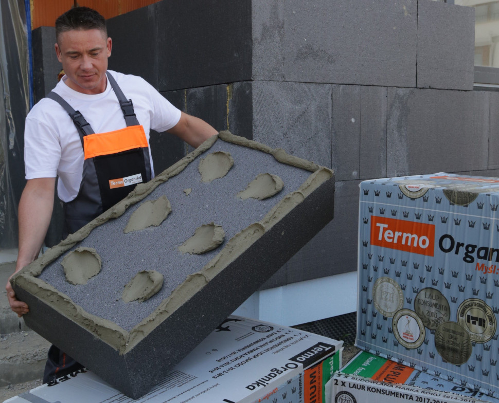 Szary styropian z linii TERMONIUM przed przyklejeniem do ściany budynku. fot. Termo Organika