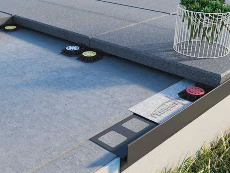 Taras wykończony płytami betonowymi ułożonymi na wspornikach montażowych i innych elementach stanowiących kompletny system tarasowy