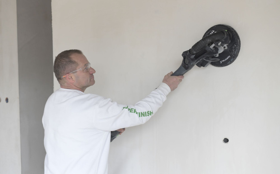 Szlifowanie gładzi Knauf Super Finish na ścianie tzw. żyrafą. fot. Knauf